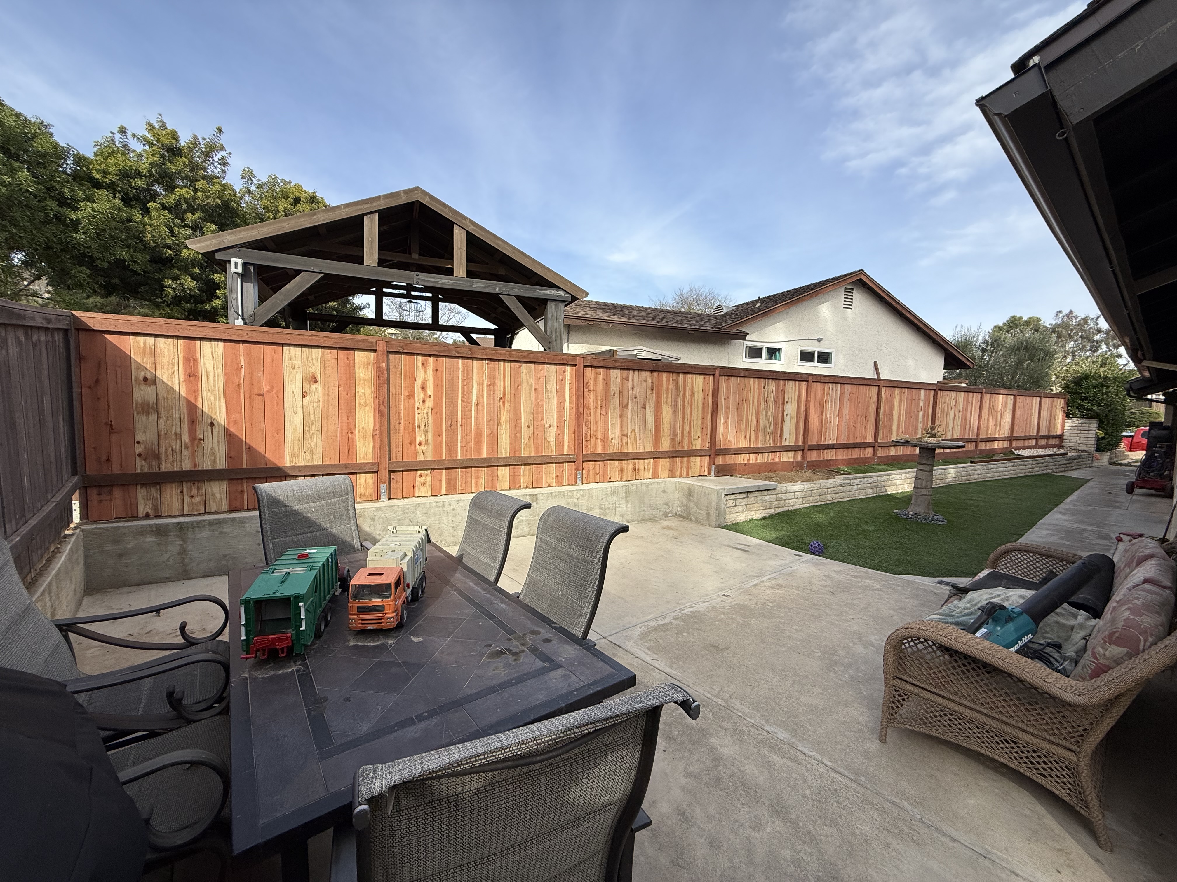 Wood fence with retaining wall and concrete patio